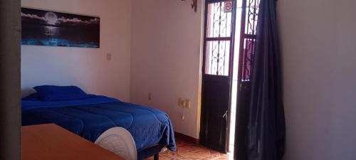 a bedroom with a bed and a window and a door at Luna y Mar in Oaxaca City