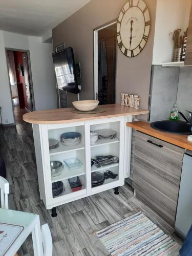 une cuisine avec un comptoir avec des assiettes et une horloge dans l'établissement HYPER CENTRE DE MARSEILLE VIEUX PORT, à Marseille