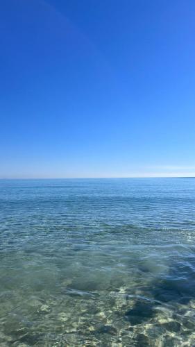 a large body of water with a blue sky at Résidence Le Marin in Banī ‘Aţāʼ