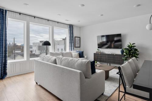 een woonkamer met een bank, een tafel en een tv bij Ivy and Ivan at The Lucy by Stay Local Nashville in Nashville