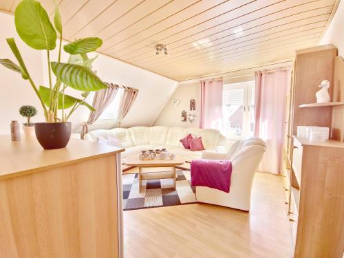 un salon avec un canapé blanc et une table dans l'établissement Dünenlounge Dornumersiel, à Dornum