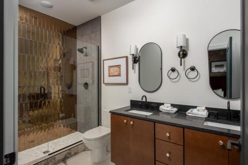 a bathroom with a toilet and a shower with two mirrors at Ivy at The Lucy by Stay Local Nashville in Nashville
