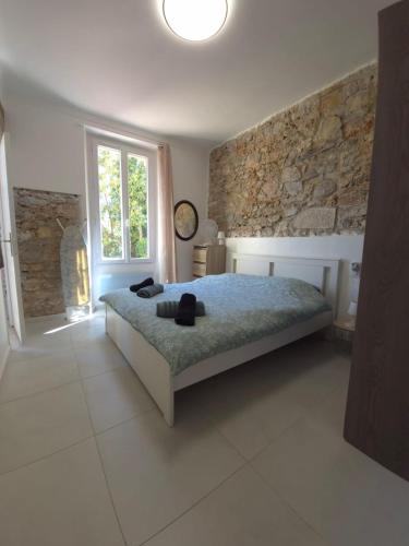 une chambre avec un lit et un mur en pierre dans l'établissement Apartment Bastide, Cannes, à Cannes