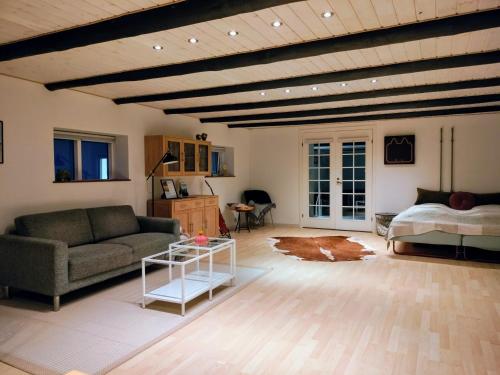 a living room with a couch and a bed at Ferielejlighed i landlige omgivelser in Ørsted