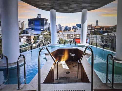 a plunge pool in a building with a view of a city at Entire flat w infinity pool and 5m walk to Fort Valley station in Brisbane