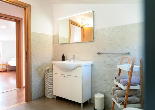 a bathroom with a white sink and a mirror at Apartments Dulcic in Stari Grad