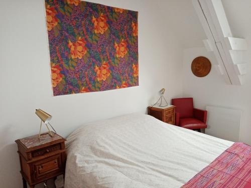 a bedroom with a bed and a painting on the wall at Rose Garden Bayeux in Bayeux