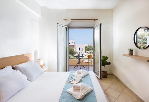Un dormitorio blanco con una cama y un balcón. en Kds Overlooking Chania, en La Canea
