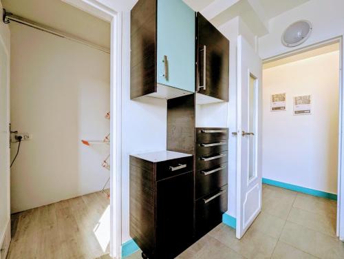 une cuisine avec un meuble noir et une porte dans l'établissement Chic apart with parking, à Mantes-la-Jolie