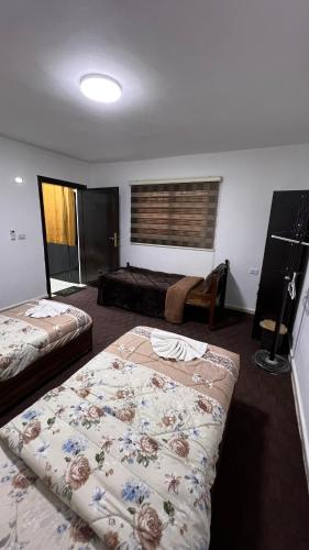 a hotel room with two beds and a window at Blue Bird House in Wadi Musa