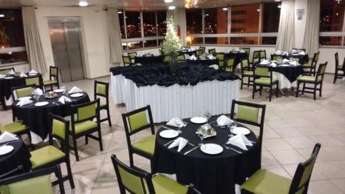 um salão de banquetes com mesas e cadeiras pretas em Hotel Vollare em Osasco