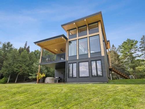 a large house on a grassy field with trees at Skyville in Cayamant