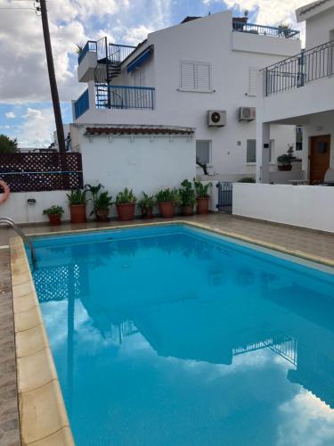 una piscina con acqua blu di fronte a un edificio di Andromeda Beach house a Polis Chrysochous