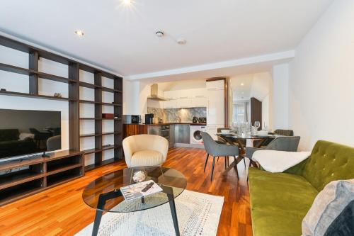 a living room with a green couch and a table at Avari Apartments - Hatton Collection in London