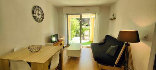 - un salon avec une table et une horloge murale dans l'établissement Beautiful apartment near the Roman Theatre Fréjus, à Fréjus