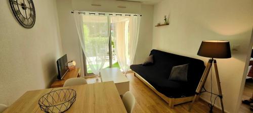 - un salon avec une table, un lit et une fenêtre dans l'établissement Beautiful apartment near the Roman Theatre Fréjus, à Fréjus