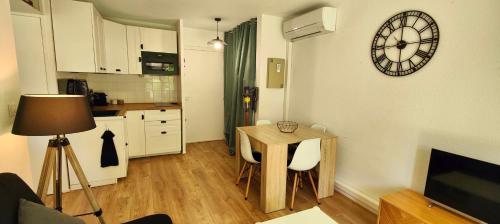 une cuisine avec une table et une horloge au mur dans l'établissement Beautiful apartment near the Roman Theatre Fréjus, à Fréjus