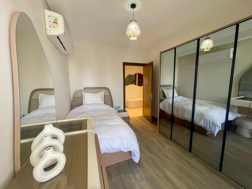 une petite chambre avec deux lits et un miroir dans l'établissement ZED Park Skyline - 3BR - Huge Terrace & City View, à Sheikh Zayed