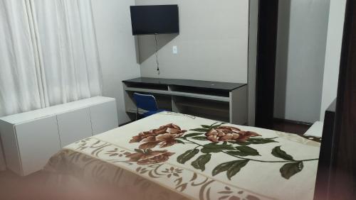 a bedroom with a bed with a table and a desk at Hostel Eldorado Contagem in Contagem