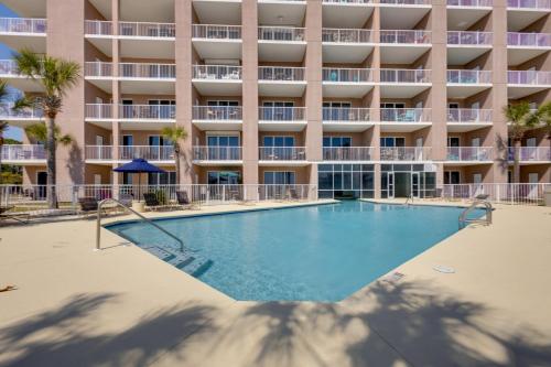 an empty swimming pool in front of a building at Walk to Beach Condo with Balcony in Gulf Shores! in Gulf Shores