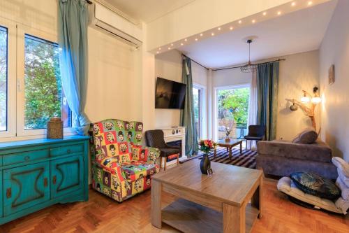 una sala de estar con un sofá y una mesa en Aiolos Elegant retro suite in GLYFADA centre, en Atenas