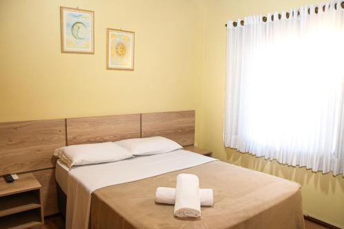 a bedroom with a bed with two towels on it at Pousada Drehmer Haus in Gramado
