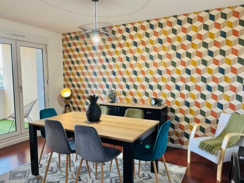 une salle à manger avec une table et des chaises avec un chat assis dessus dans l'établissement Grand appart 4 chambres, à Épinal