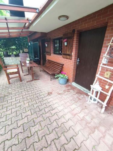 a patio with a wooden bench and a building at Chata pod Luhačovickou přehradou in Pozlovice