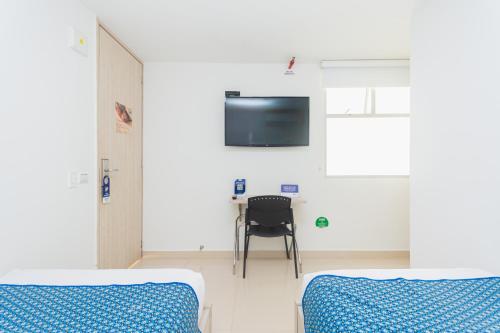 a hospital room with two beds and a tv at Hotel Laureles Plaza in Medellín