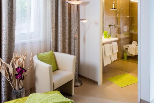 y baño con silla blanca y ducha. en B&B Villa Verde, en Salzburgo