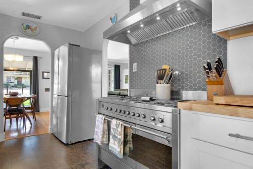 a kitchen with a stainless steel stove and a table at MIDCENTURY MANOR-Hot Tub & 5 Blocks to Town Center in Paso Robles