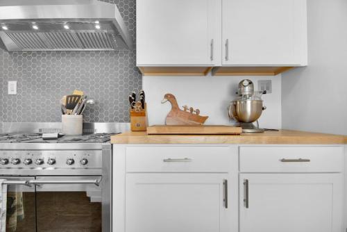 a kitchen with white cabinets and a stove at MIDCENTURY MANOR-Hot Tub & 5 Blocks to Town Center in Paso Robles