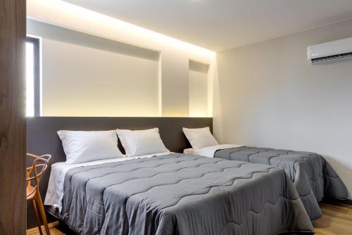 two beds sitting next to each other in a room at Villano Hotel in Blumenau