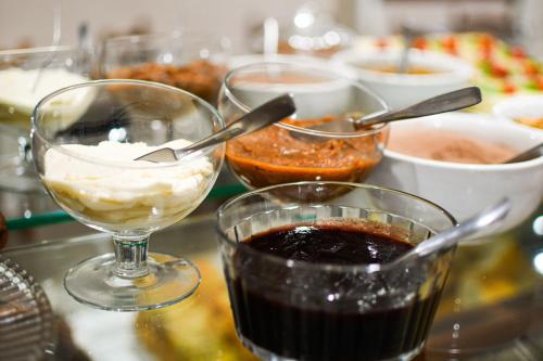 a table with bowls of food and glasses of sauce at Pousada Drehmer Haus in Gramado