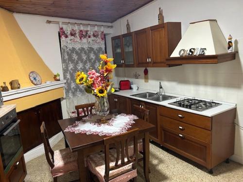 a kitchen with a table with a vase of flowers on it at Civico 31 in Terralba