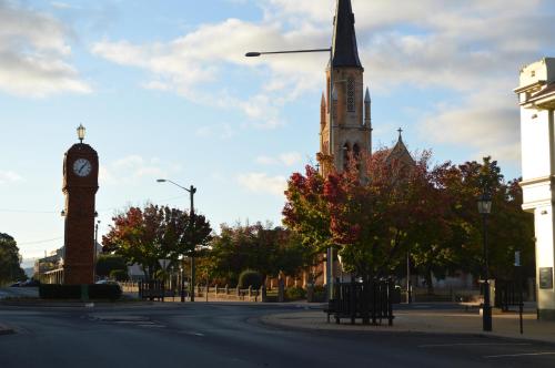 a tall clock tower with a clock on a building at Wanderlight Motor Inn in Mudgee
