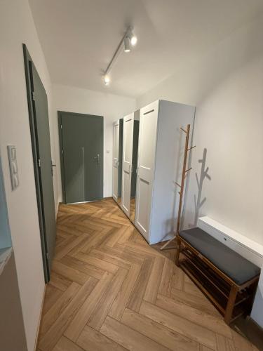 a hallway of an empty room with a wooden floor at Apartament Forest Elegance in Charzykowy