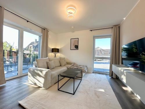 ヘンシュテット・ウルツブルクにあるHarmony Homes - Nähe Bahnhof - Terasse - Smart-TV - Nähe Hamburg & Flughafenのソファとテーブルのあるリビングルーム