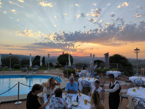 a group of people sitting around tables by a pool at Relais Todini - Residenza d'epoca - Luxury Historic house in Todi
