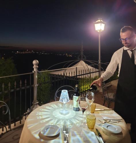 a man is sitting at a table with wine glasses at Relais Todini - Residenza d'epoca - Luxury Historic house in Todi