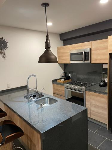 a kitchen with a sink and a stove at Apartment in La Roma, Pool&GYM in Mexico City