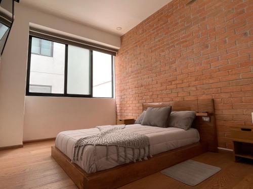 a bedroom with a brick wall and a bed at Apartment in La Roma, Pool&GYM in Mexico City