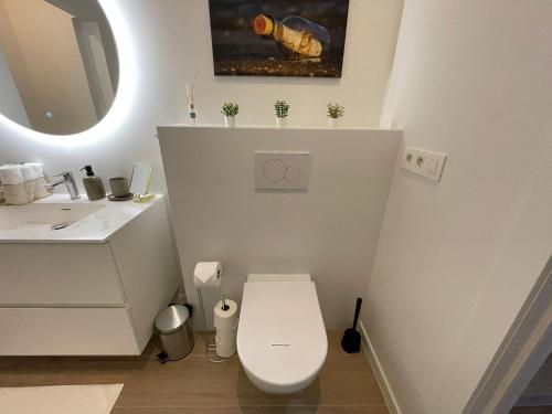a white bathroom with a toilet and a sink at OneLuxStay near Antwerp Central in Antwerp