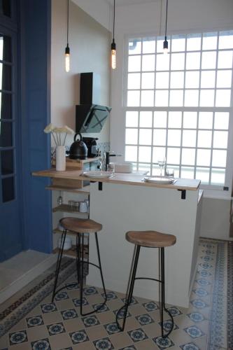 une cuisine avec deux tabourets de bar et un comptoir dans l'établissement Clos Canteleu, à La Rivière-Saint-Sauveur