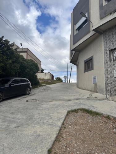 a car parked in a driveway next to a building at 3 Appartements Vue sur Mer dans une maison indépendante in Tangier