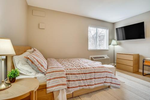 布莱恩Convenient Studio Stay Easy Access to Twin Cities的一间卧室，配有一张床、一张桌子和一台电视机