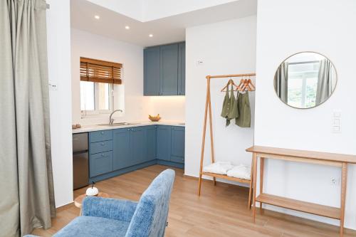 アダマスにあるAegean Blue - Volia Deluxe apartのキッチン(青いキャビネット、青い椅子付)