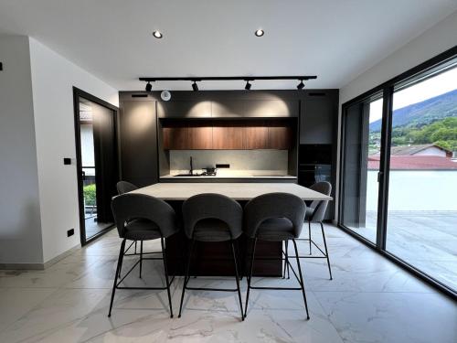 une cuisine avec une table et des chaises dans une pièce dans l'établissement Appartement 2chambres entre lac et montagnes, à Sévrier