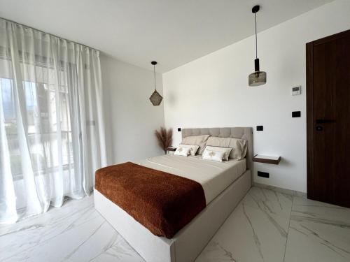 - une chambre blanche avec un grand lit et une grande fenêtre dans l'établissement Appartement 2chambres entre lac et montagnes, à Sévrier