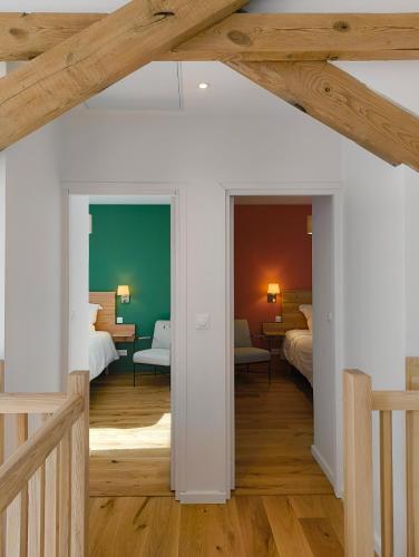 une chambre avec deux lits et un salon dans l'établissement LES PATICHERES - La Grange avec accès à la piscine, à Biville-la-Baignarde